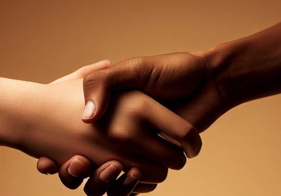 Two hands of different skin tones shaking firmly as a sign of a successful negotiation of a debt settlement.